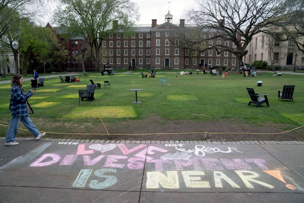 A message in chalk decorates a sidewalk Tuesday after an encampment protesting the Israel-Hamas war was taken down at Brown University in Providence, R.I.  
